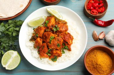 Pirinç, maydanoz, kireç ve baharatlı leziz tavuk tikka masala açık mavi ahşap masa, düz yatıyordu