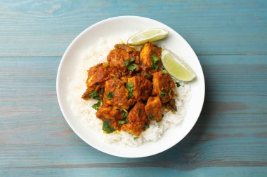 Pirinç, maydanoz ve limonlu leziz tavuk tikka masala açık mavi ahşap masa, üst manzara