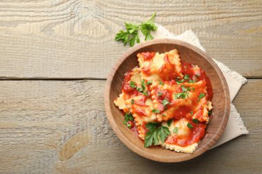 Domates soslu lezzetli ravioli ve ahşap masada maydanoz, üst manzara. Metin için boşluk