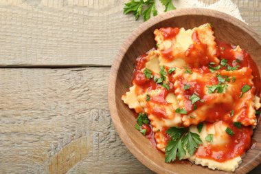 Domates soslu lezzetli ravioli ve ahşap masada maydanoz, üst manzara. Metin için boşluk