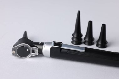 Duyma testi. Açık gri arkaplan üzerine modern otoskop ve kulak spekulumları, yakın plan