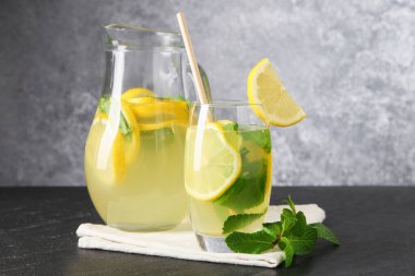Limonlu taze limonata, siyah masada nane şekeri, yakın plan.
