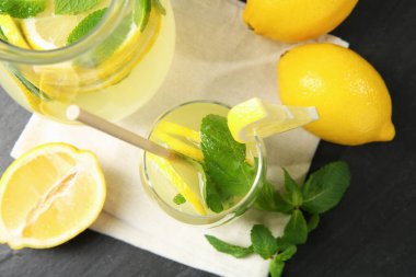 Bardakta taze limonata, sürahi, limon ve nane şekeri siyah masada, düz yatıyordu.