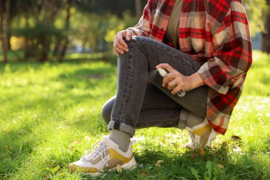 Park halindeki bacağa kene püskürten kadın, yakın plan. Metin için boşluk