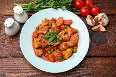 Lezzetli pişirilmiş güveç ve ahşap masa üzerinde malzemeler, düz yatıyordu.