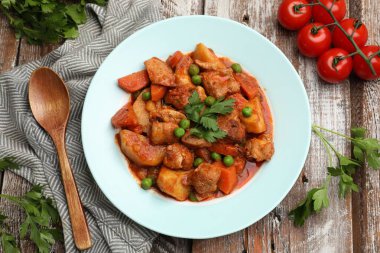 Ahşap masada servis edilen nefis pişmiş güveç, düz yerde.