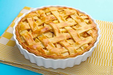 Açık mavi arkaplanda ev yapımı elmalı turta, yakın plan.