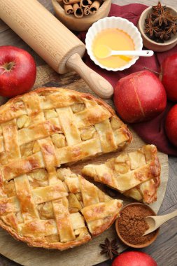 Lezzetli ev yapımı elmalı turta ve ahşap masa üzerindeki malzemeler.