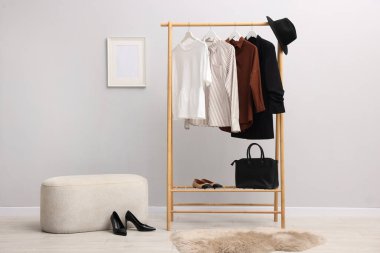 İçerideki duvarın yanında farklı şık kıyafetler, aksesuarlar ve ayakkabılar.