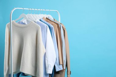 Açık mavi arkaplanda asılı farklı giysiler, metin için boşluk