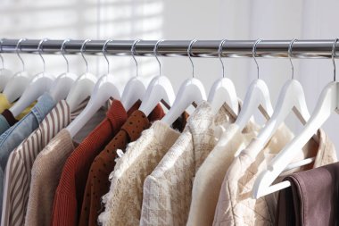 Farklı şık kıyafetler askıda asılı, kapalı, yakın çekim.