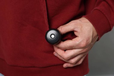 Gri arka planda gizli casus kamerası olan adam, yakın plan.