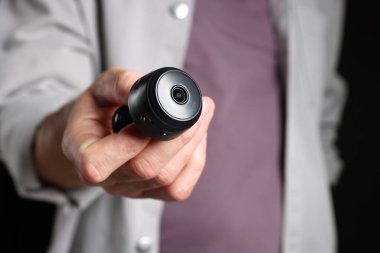 Siyah arka planda gizli casus kamerası olan adam, yakın plan.