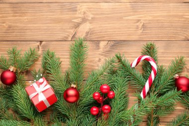 Noel ağacı dalları, şenlikli dekorlar, hediye kutusu ve tahta masa üzerinde şeker kamışı, düz yatış. Metin için boşluk