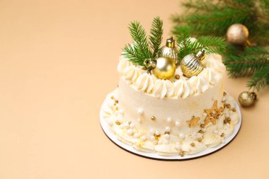 Bej arka planda Noel dekoru olan lezzetli bir pasta, yakın plan. Metin için boşluk