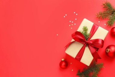 Firavun ağacı dalları, hediye ve kırmızı arka planda Noel süsü, düz bir zemin. Metin için boşluk