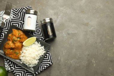 Tuz, karabiber, limon, tavuk tikka masala ve gri masada pirinç, düz yatak. Metin için boşluk