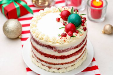 Noel dekorlu lezzetli sünger keki, hediye kutusu ve yanan mumlar, yakın plan.