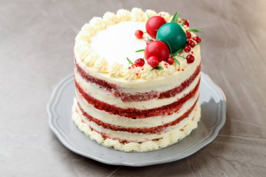 Noel dekorlu lezzetli sünger keki ve gri desenli masa üzümlü kırmızı üzümlü, yakın plan.