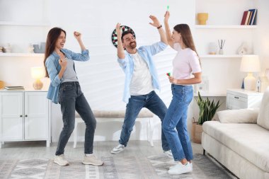 Evde dart oynayan üç mutlu arkadaş.