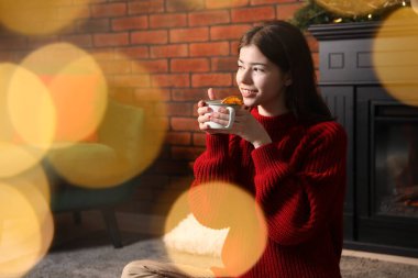 Evde nefis sıcak içkisi olan bir kadın. Bokeh etkisi