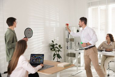 Bir grup meslektaşım ofiste dart oynuyor.