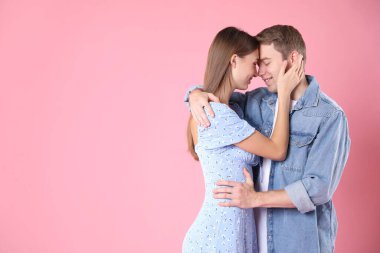 Pembe arka planda kucaklaşan sevimli bir çift, mesaj için yer var. Romantik randevu