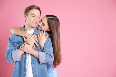 Pembe arka planda kucaklaşan sevimli bir çift, mesaj için yer var. Romantik randevu