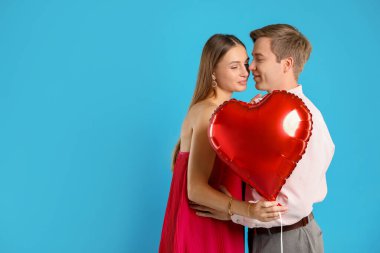 Açık mavi arka planda kalp şeklinde balonları olan sevimli bir çift, mesaj için yer var. Romantik randevu