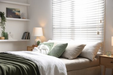 Büyük yataklı, yastıklı, çiçekli ve lambalı şık bir yatak odası. İç tasarım