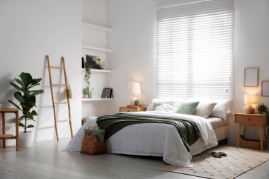 Büyük yataklı, yastıklı, çiçekli ve lambalı şık bir yatak odası. İç tasarım