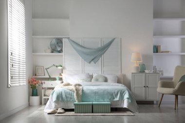 Büyük yataklı, yastıklı ve lambalı şık bir yatak odası. İç tasarım