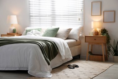 Büyük yataklı, yastıklı, çiçekli ve lambalı şık bir yatak odası. İç tasarım