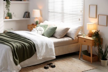 Büyük yataklı, yastıklı, çiçekli ve lambalı şık bir yatak odası. İç tasarım