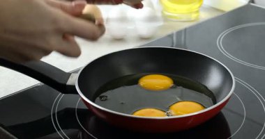 Mutfakta yumurta kıran bir kadın, yakın plan.