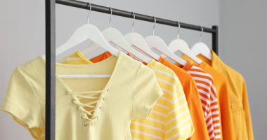 Farklı şık elbiseleri olan, kapalı mekanlı, yakın plan bir kadın.