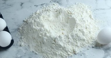 Beyaz mermer masada un üzerine çiğ yumurta kırmak, yakın plan.