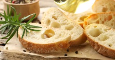Ciabatta dilimlerinin üzerine yağ dök, ahşap masaya, yakın çekim.