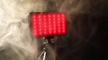 LED lamba kırmızı ışık ve tripodun üzerinde koyu arkaplan üzerinde duman, yakın çekim