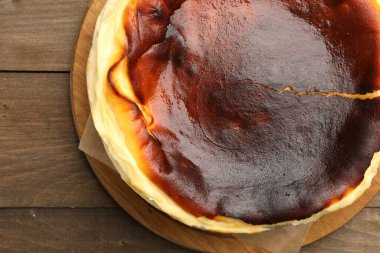 Lezzetli Bask cheesecake 'i ahşap masada, üst manzara.