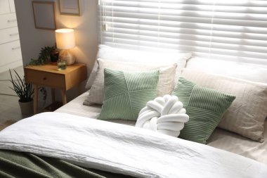 Büyük yataklı, yastıklı, çiçekli ve lambalı şık bir yatak odası. İç tasarım