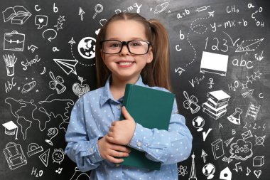 Siyah karatahtanın yanında gözlüklü şirin bir çocuk.