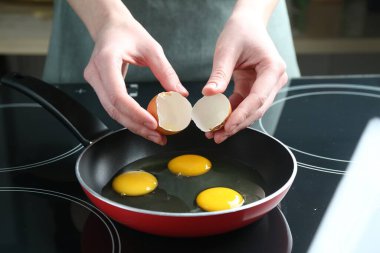 Mutfakta yumurta kıran bir kadın, yakın plan.