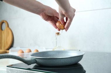 Mutfakta yumurta kıran bir kadın, yakın plan.