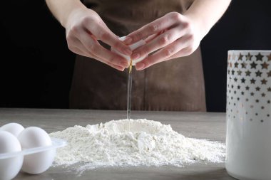 Ahşap masada yumurta kıran kadın, yakın plan.