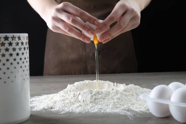 Ahşap masada yumurta kıran kadın, yakın plan.