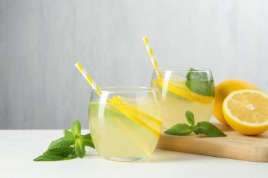 Taze limonata, limon ve nane şekeri beyaz masada, yakın plan.