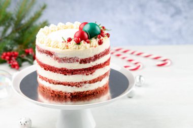 Noel dekorlu lezzetli sünger keki ve beyaz ahşap masa üzerinde üzümlü üzümlü üzümlü gri arka plan, yakın plan. Metin için boşluk