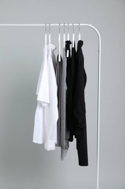 Gri arka planda askıda asılı farklı kıyafetler