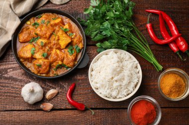 Tavuklu tikka masala, pirinç ve baharatlar ahşap masada, düz yerde.